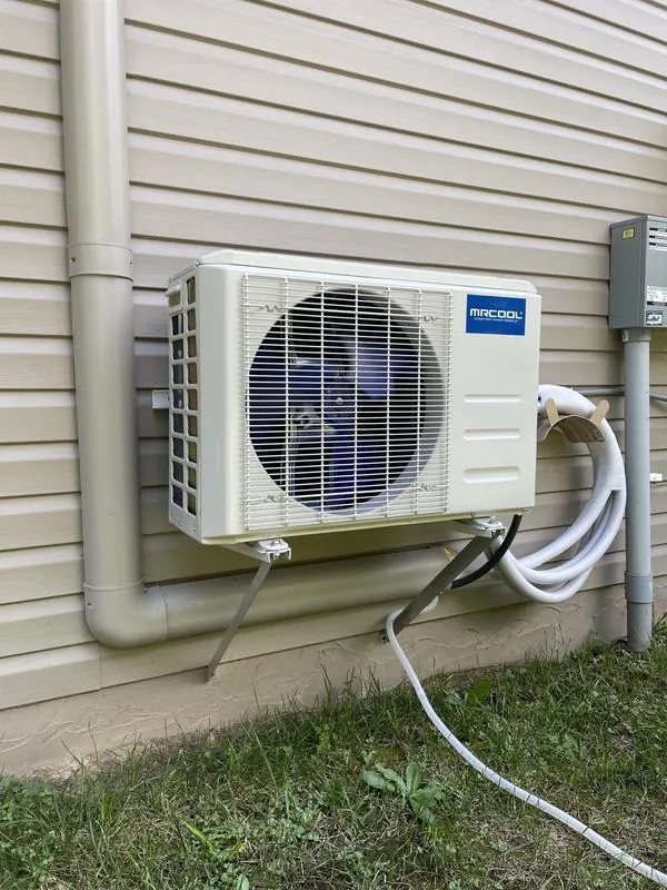 MRCOOL DIY outdoor condenser mounted on a wall bracket with quick-connect line set
